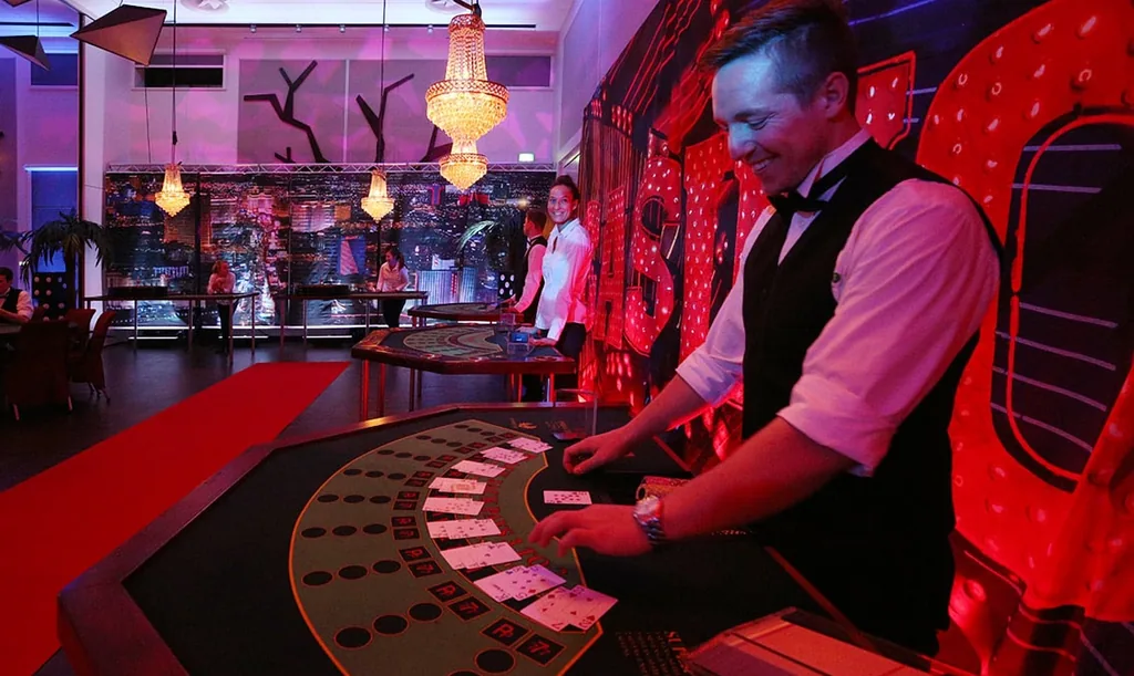 Dealer deler kort ud ved blackjackbordet under rødt casinolys