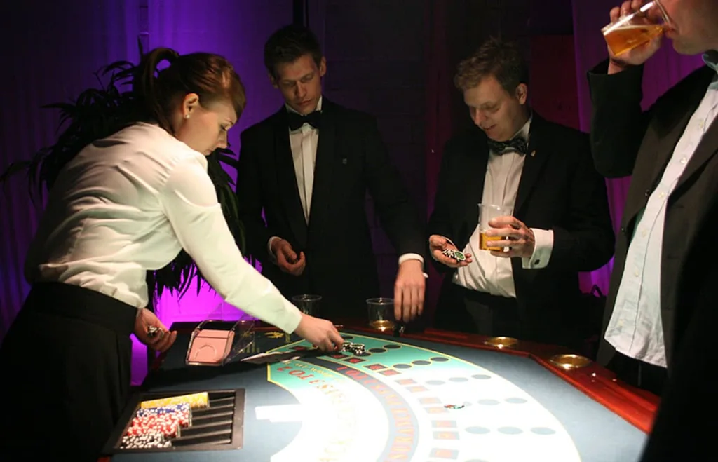 Dealer ved blackjackbordet med gæster i smoking