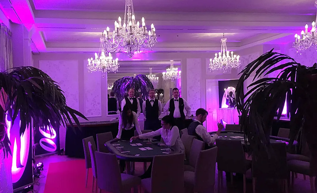 Casinosal med lysekroner, palmer og dealere klar ved bordene