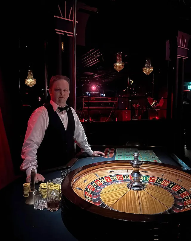 Dealer ved roulettebordet i dæmpet lys